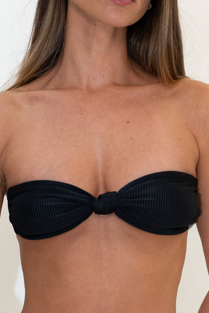 KAYA black ribbed bandeau bikini top by Almaya Swimwear, featuring a strapless design and knotted front detail.